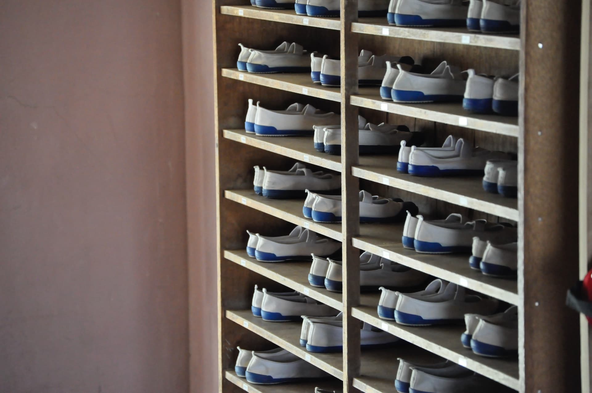 A rack of bowling shoes in order.