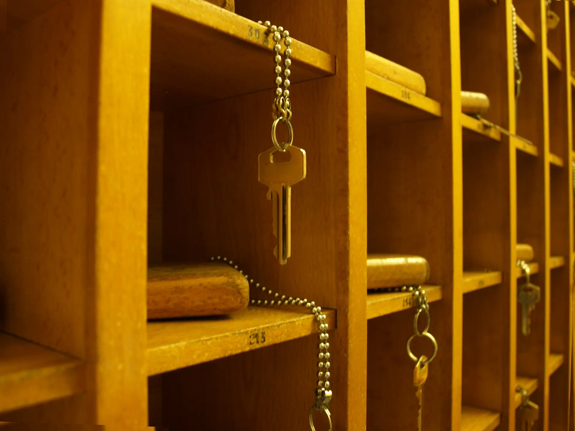 Old timey hotel keys in pigeon holes made of wood.