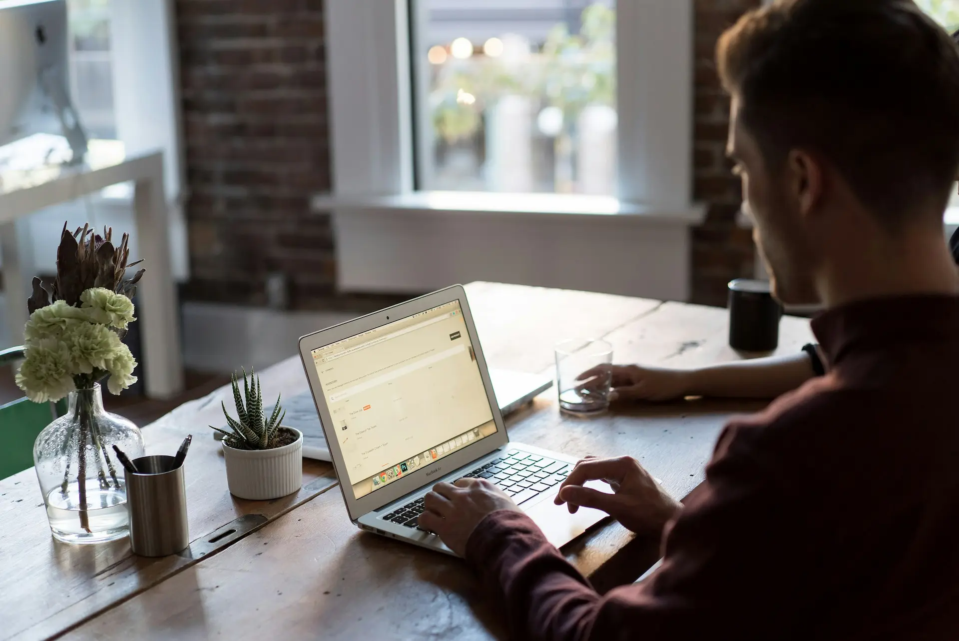 Photo of a guy working on his laptop in a coworking space.