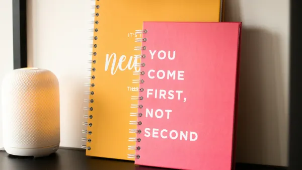 Two notebooks on a table. Text on the top one reads You come first, not second.