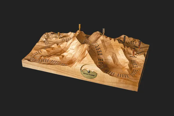 Wooden CNC made model of Mount Everest with holes for paths and pegs denoting camps.