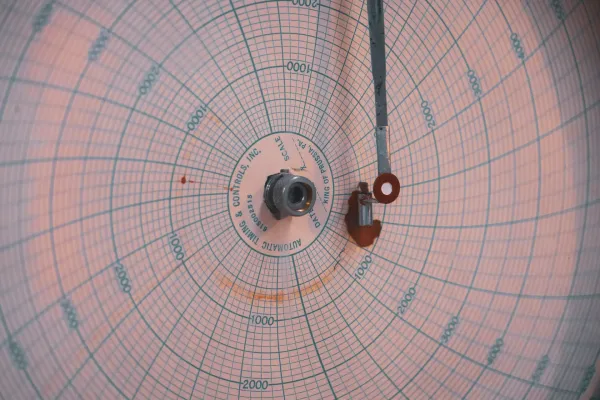 A retro analogue circular gauge that works similarly like a seismograph from a nuclear reactor.